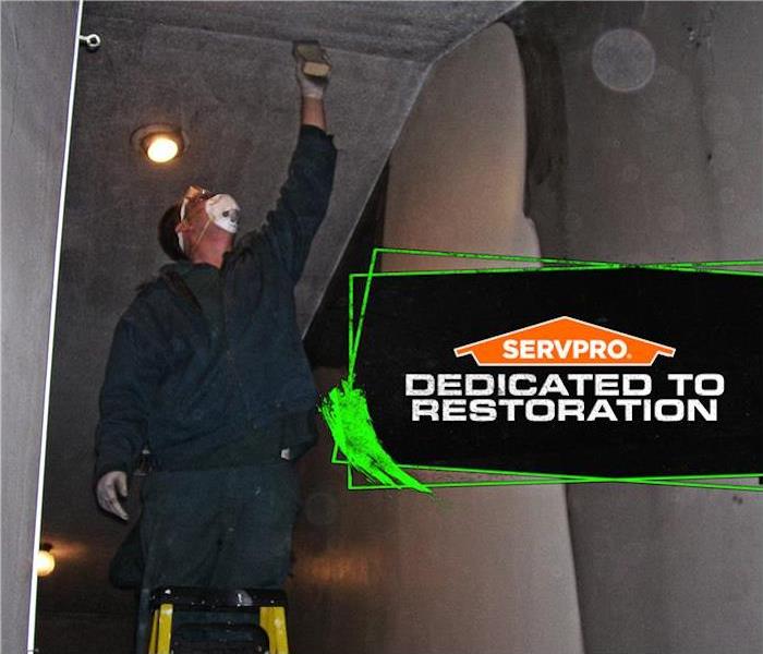 tech removing soot from walls  servpro poster